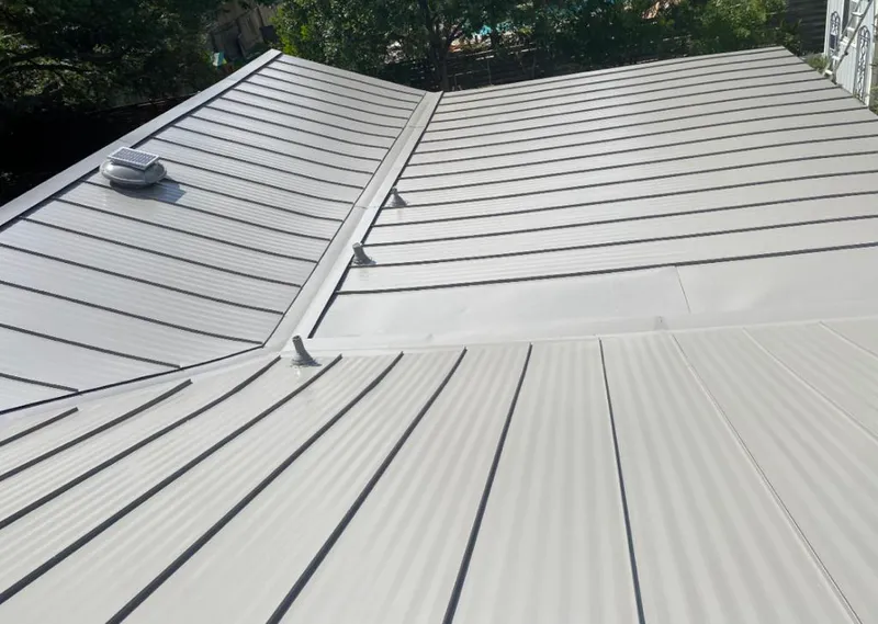 Solar attic fan installed on a metal roof for Roof Ventilation in Norman