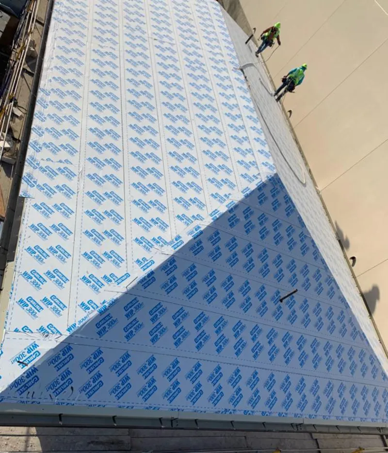 Professional roofers installing underlayment on a metal roof in Norman